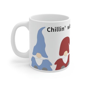 May include: White ceramic coffee mug with a blue and red gnome design. The text "Chillin' with my gnomes" is printed on the mug.