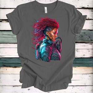 May include: A gray t-shirt with a colorful illustration of a woman with red hair and a futuristic outfit. The woman has a cybernetic implant on her head and is looking to the side.
