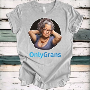 May include: A gray t-shirt with a cartoon image of an older woman with gray hair and glasses. The woman is wearing a blue dress and a necklace. The text "OnlyGrans" is printed in blue below the image.