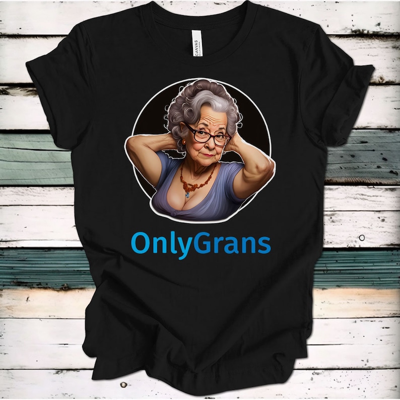 May include: Black t-shirt with a cartoon image of an older woman with gray hair and glasses. The woman is wearing a blue shirt and a necklace. The text "OnlyGrans" is printed in blue below the image.
