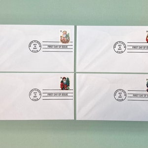 May include: Four white envelopes with Santa Claus stamps. Each envelope has a "Santa Claus" stamp and a "First Day of Issue" postmark dated October 10, 2001. The stamps feature Santa in various poses.
