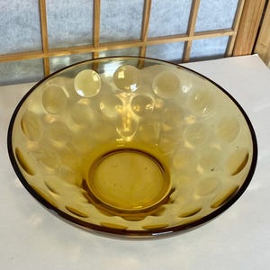 May include: A large amber glass bowl with a textured, bubbled surface. The bowl is empty and ready to be filled.
