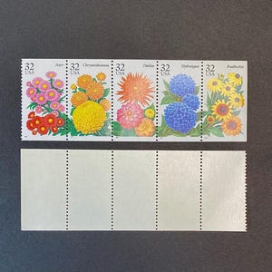 May include: A sheet of five 32-cent US postage stamps featuring colorful flower illustrations. The stamps are arranged in a row and feature the following flowers: Aster, Chrysanthemum, Dahlia, Hydrangea, and Rudbeckia.