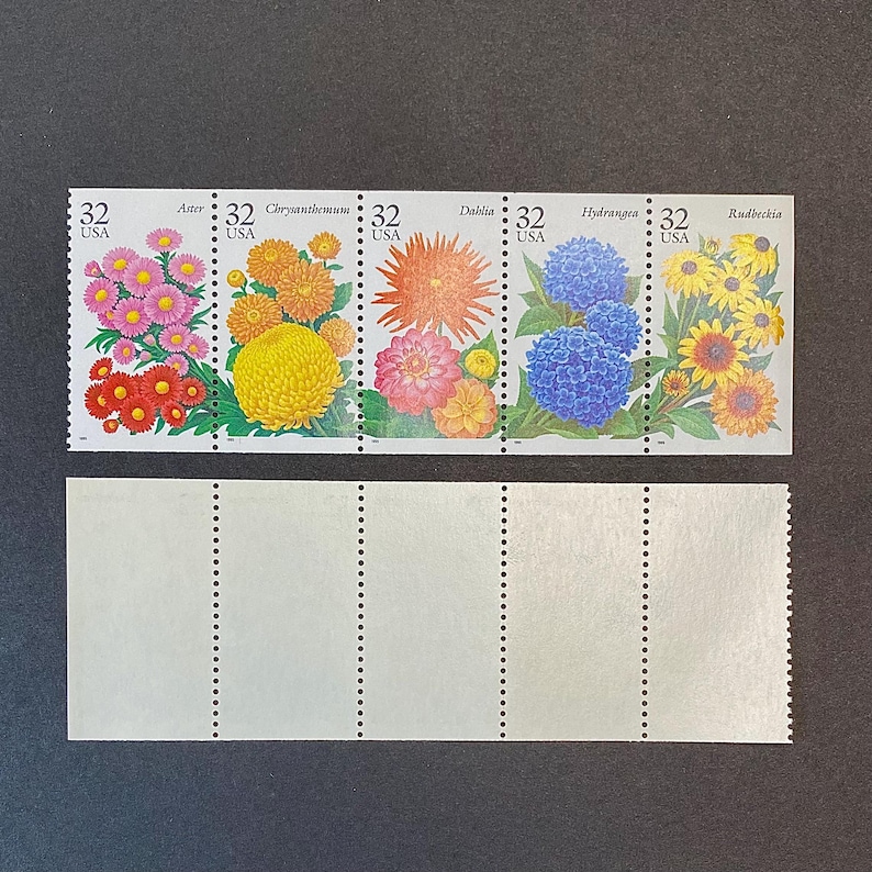 May include: A sheet of five 32-cent US postage stamps featuring colorful flower illustrations. The stamps are arranged in a row and feature the following flowers: Aster, Chrysanthemum, Dahlia, Hydrangea, and Rudbeckia.