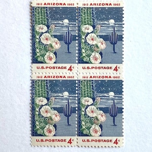 May include: A sheet of four 4-cent United States postage stamps. The stamps feature a blue and white illustration of a desert landscape with a saguaro cactus and blooming flowers. The text "1912 ARIZONA 1962" and "U.S. POSTAGE 4¢" are printed on each stamp.