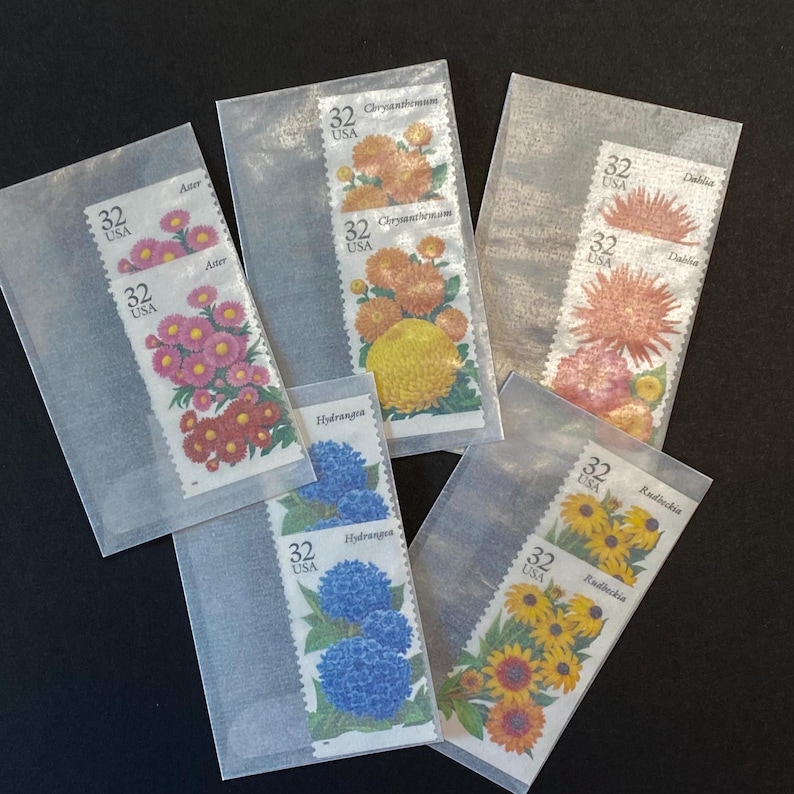 May include: A set of six vintage US postage stamps featuring different types of flowers. The stamps are in protective plastic sleeves. The flowers include Aster, Chrysanthemum, Dahlia, Hydrangea, and Rudbeckia.