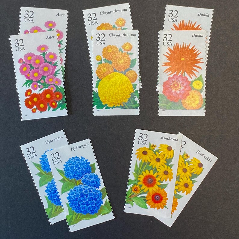May include: A collection of eight vintage US postage stamps featuring different types of flowers. The stamps are all 32 cents and feature the following flowers: Aster, Chrysanthemum, Dahlia, Hydrangea, and Rudbeckia.