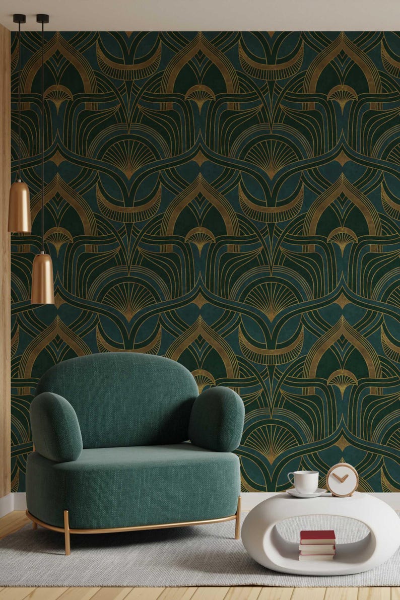 Op de afbeelding: Een groene fluwelen fauteuil met gouden metalen poten staat voor een muur met een donkergroen en gouden geometrisch patroon behang. Een witte bijzettafel met een kopje en een klok staat naast de fauteuil.