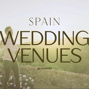 May include: Two individuals stand outdoors against a sunset landscape with a stone wall and white flowers. The text SPAIN WEDDING VENUES and @LEIAMAE9 are overlaid in dark brown lettering across the center of the bright, sunlit scene.