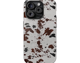 May include: A phone case with a cowhide pattern. The case features a white background with brown and black splotches, mimicking the look of cowhide. The case has a camera module with three lenses and a flash.