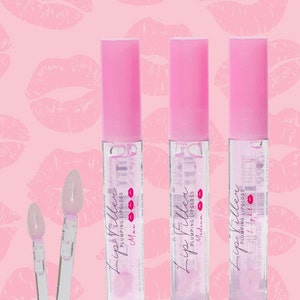 May include: Three clear lip gloss tubes with pink caps and labels that say "Lip Filler Plumping Lip Gloss" with the words "Max", "Medium", and "Light" printed below.