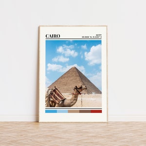 May include: A camel stands in front of the Great Pyramid of Giza in Cairo, Egypt. The sky is blue with white clouds. The image includes a color palette of blue, light blue, brown, tan, and red.