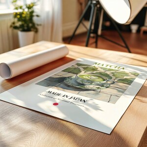 May include: A poster with a green and white illustration of a cup of matcha tea with a heart design in the foam. The poster has the text "MATCHA" and "MADE IN JAPAN Collection of National Treasures" on it.