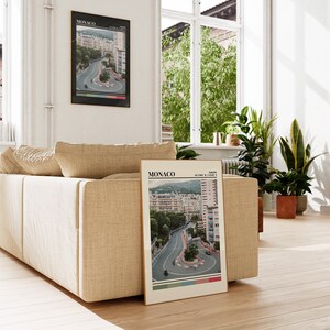 Peut inclure: Une affiche &agrave; l'esth&eacute;tique vintage repr&eacute;sentant une vue a&eacute;rienne du circuit du Grand Prix de Monaco. L'affiche est intitul&eacute;e "MONACO" et comprend les coordonn&eacute;es "43.7346&deg; N, 7.4208&deg; E".