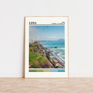 May include: A framed print of a coastal city with a beach, ocean, and cliffs. The print includes the text "LIMA" and "PERU 12.0464° S, 77.0428° W". The print also includes a color palette of green, brown, blue, and teal.
