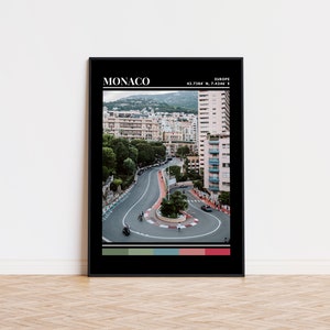 Peut inclure: Une photo en noir et blanc d'une route sinueuse &agrave; Monaco, en Europe. La route est entour&eacute;e de b&acirc;timents et d'arbres. La photo est encadr&eacute;e d'un cadre noir avec le mot "MONACO" et les coordonn&eacute;es "43.7384&deg; N, 7.4246&deg; E" imprim&eacute;es en blanc en haut.