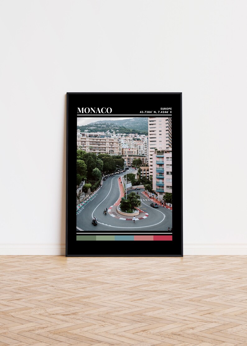 Peut inclure: Une photo en noir et blanc d'une route sinueuse &agrave; Monaco, en Europe. La route est entour&eacute;e de b&acirc;timents et d'arbres. La photo est encadr&eacute;e d'un cadre noir avec le mot "MONACO" et les coordonn&eacute;es "43.7384&deg; N, 7.4246&deg; E" imprim&eacute;es en blanc en haut.