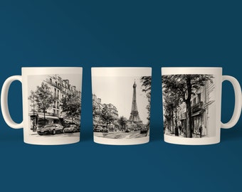 May include: Three white ceramic mugs with black and white illustrations of a Parisian street scene. The mugs feature a view of the Eiffel Tower in the distance, buildings, trees, and people walking down the street.