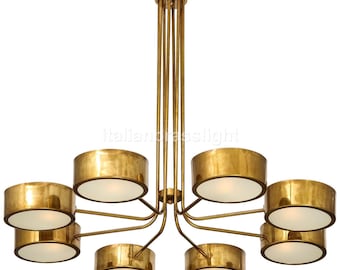 May include: A brass chandelier with eight round light fixtures. The chandelier has a central stem with multiple arms extending outwards, each supporting a light fixture. The light fixtures have a gold finish and white shades.