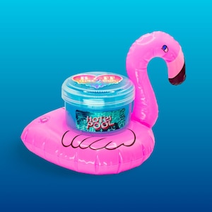 May include: A pink inflatable flamingo pool float with a clear plastic container of blue slime inside. The container has a label that says "Hotel Pool" and a heart with the words "Slime Bakery" on it.
