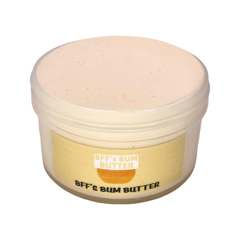 May include: A white plastic jar with a yellow label that reads "BFF's Bum Butter". The jar is filled with a light pink cream.