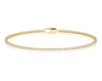 May include: A delicate gold tennis bracelet with a row of small, sparkling diamonds.