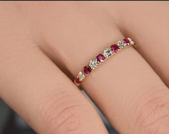 May include: A gold band ring with alternating red rubies and white diamonds.