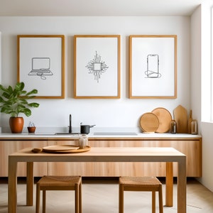 May include: A modern kitchen with a wooden table and chairs, a white countertop, and three framed illustrations on the wall. The illustrations depict a laptop, a circuit board, and a smartphone.