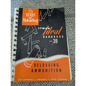 May include: A spiral-bound book titled "Lyman Ideal Handbook No. 39" with the text "75 Years of Reloading." The cover is black and orange, featuring illustrations of bullets and the words "Reloading Ammunition."