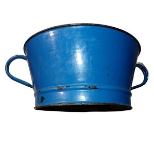May include: A vintage blue enamelware bucket with two curved handles. The bucket has a rounded shape with a black rim and shows signs of wear, adding to its antique charm. The bucket is empty and sits against a white background.