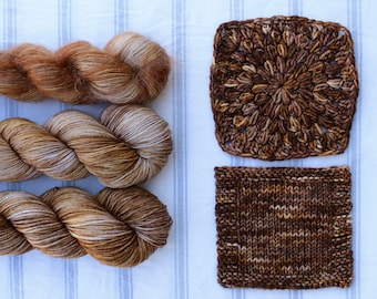 May include: Three skeins of brown and cream yarn with a crocheted square and a knitted square made from the yarn.