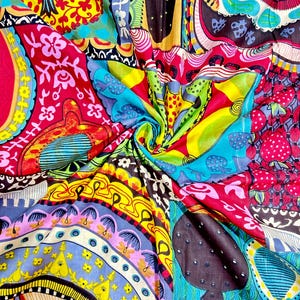 May include: A colorful fabric with a patchwork design featuring various geometric shapes, flowers, and abstract patterns in shades of red, yellow, blue, green, and black.