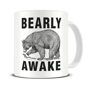 May include: White ceramic coffee mug with a black bear illustration and the text "Bearly Awake".