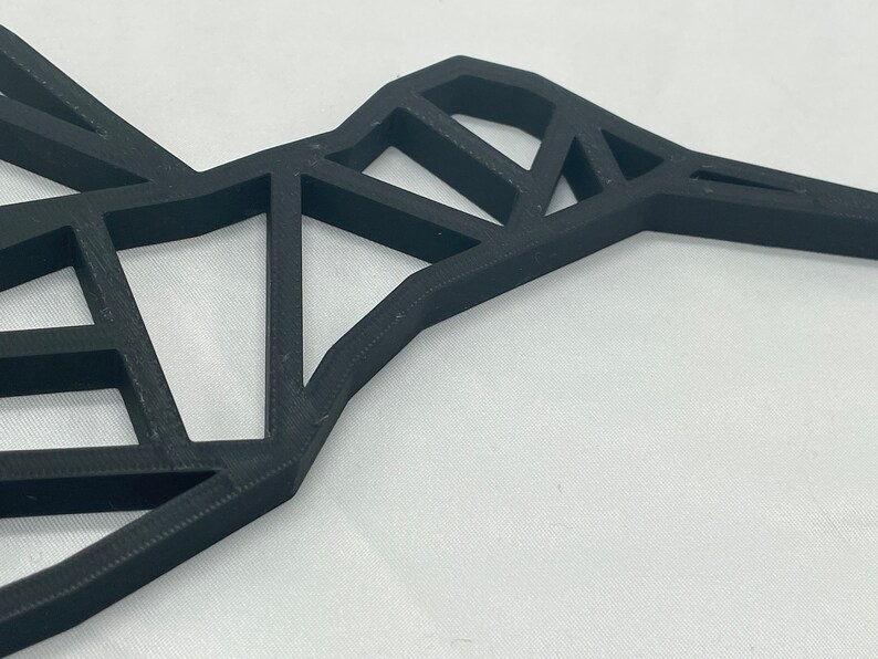May include: A black geometric hummingbird wall decor made of 3D printed plastic.