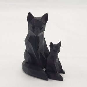 May include: A black, geometrically designed fox figurine with a smaller fox figurine sitting beside it.