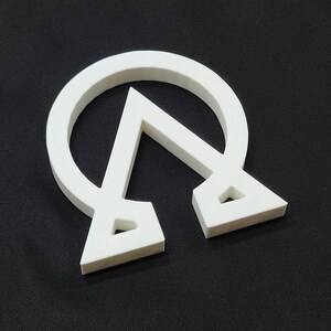 May include: White plastic symbol of a circle with a triangle inside, resembling the Greek letter Omega with a triangle inside.