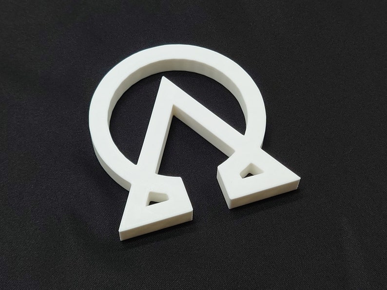 May include: White plastic symbol of a circle with a triangle inside, resembling the Greek letter Omega with a triangle inside.
