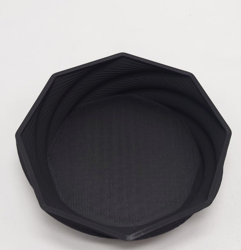 May include: A black octagonal bowl with a textured surface. The bowl is made of a hard plastic material.