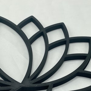 May include: Black lotus flower design wall decor. The design is made of multiple layers of thin black metal, creating a 3D effect.