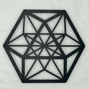 Pu&ograve; includere: Decorazione da parete in legno geometrica nera con forma esagonale e design intricato.