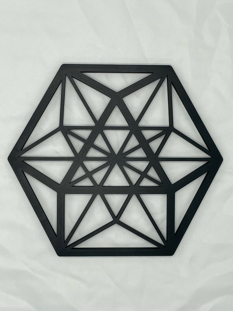 Pu&ograve; includere: Decorazione da parete in legno geometrica nera con forma esagonale e design intricato.
