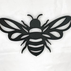 May include: Black metal bee cutout with detailed wings and a striped body.