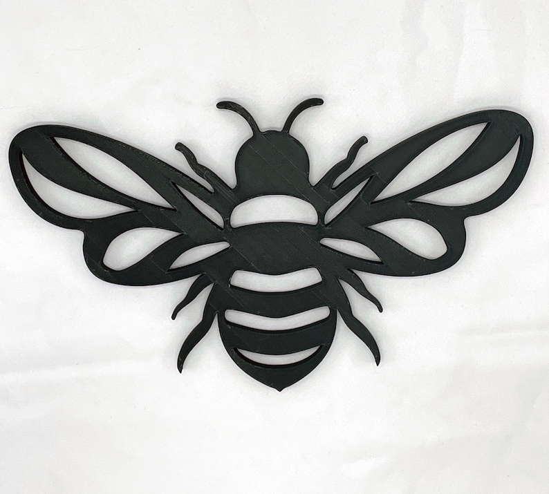 May include: Black metal bee cutout with detailed wings and a striped body.