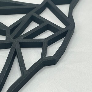 May include: A black geometric design with a 3D effect. The design is made of many triangles and squares that are connected together. The design is abstract and modern.