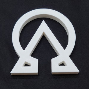 May include: White plastic symbol of the Chi Rho, a Christian symbol representing the first two letters of Christ's name in Greek.
