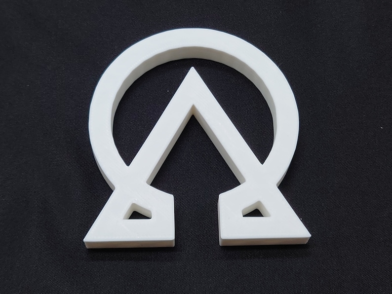 May include: White plastic symbol of the Chi Rho, a Christian symbol representing the first two letters of Christ's name in Greek.