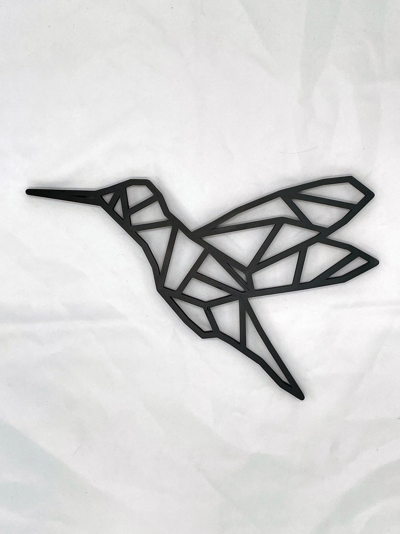 May include: Black geometric hummingbird wall decor. The hummingbird is made of metal and has a modern, minimalist design.