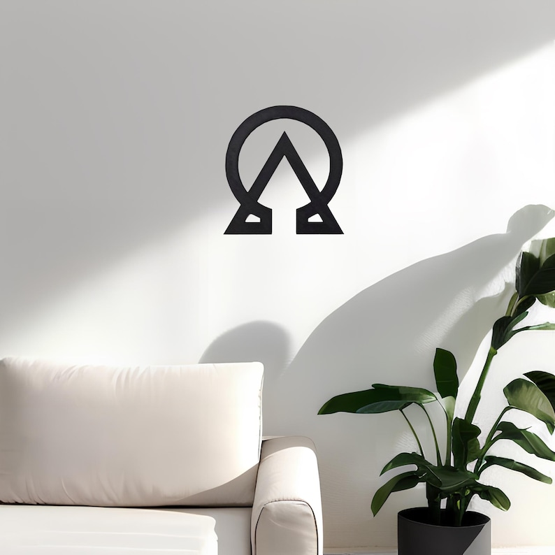 May include: Black metal wall decor featuring a stylized symbol with a circle and a triangle. The symbol is mounted on a white wall.
