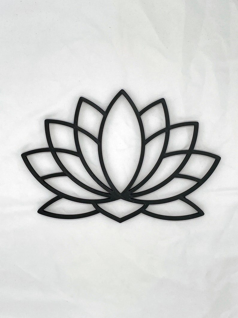 May include: Black metal lotus flower wall decor. The design is intricate and detailed, with a geometric pattern.