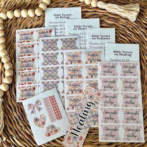 May include: A collection of adhesive Bible index tabs featuring floral and plaid patterns with text labels including Refuge, Healing, Sickness, and Weariness. The set includes a rectangular bookmark with the word Healing and several decorative stickers.